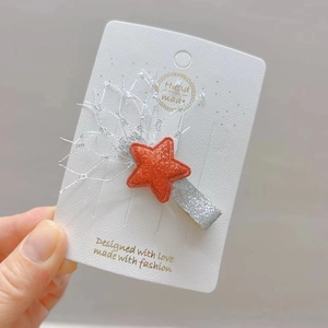 Détail de la pince à cheveux étoile pailletée orange avec dentelle et carte cadeau