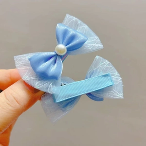 Détail de pinces à cheveux avec nœuds en résille bleue et perle blanche pour filles