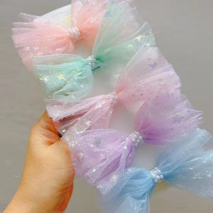 Détail de cinq barrettes à nœuds en résille avec perles et paillettes pastel variées
