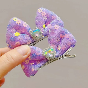 Detail of purple mesh bow hair clips with heart-shaped rhinestone and floral prints