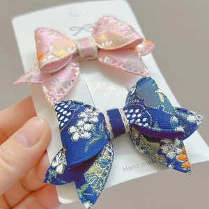 Dettaglio di fermagli per capelli con fiocco floreale fatti a mano rosa e blu