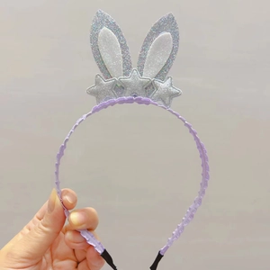 Detail of purple bunny ear headband featuring shimmering glitter stars and pleated fabric