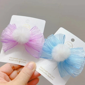 Primer plano de pinzas para el cabello con lazos de tul y pompones de pelo sintético