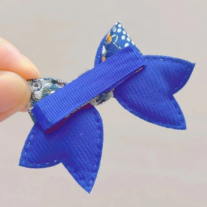 Dettaglio del fermaglio a fiocco in nastro blu con clip a coccodrillo in metallo rivestito