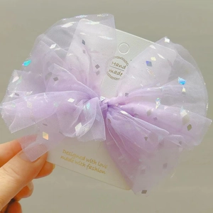 Dettaglio del fermaglio per capelli a fiocco in tulle viola con paillettes luccicanti