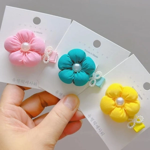 Detailed view of handmade fabric flower hair clips with faux pearls in soft candy colors