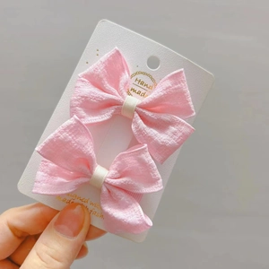 Paire de barrettes à nœud rose en tissu pour filles sur carte de présentation