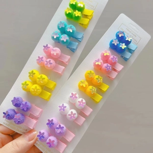 Close-up of glittery sequin flower and colorful plush pom pom hair clips for girls