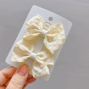 Ensemble de deux pinces à cheveux à nœud en tissu jaune pâle pour petites filles