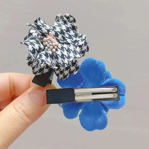 Detail of flower hair clips in houndstooth and blue velvet with black metal duckbill clips