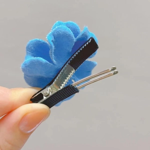 Detailed back view of a blue fabric flower hair clip with a non-slip metal duckbill clip