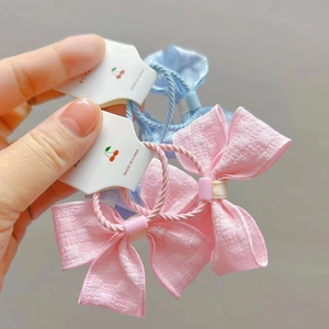 Détail des chouchous nœuds en tissu rose et bleu sur des cartes à motif cerise