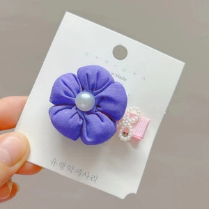 Purple fabric flower hair clip with pearl center on pink ribbon display card