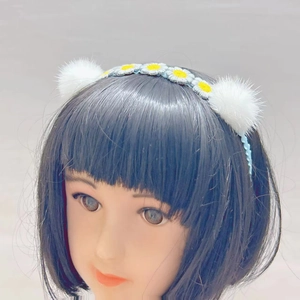 Detailed view of handmade crochet headband with mink fur balls and daisy flower embroidery