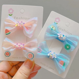 Détail des barrettes nœuds scintillantes avec breloques de fruits et perles pour filles