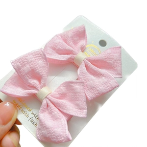 Paire de barrettes à nœuds en tissu rose pour filles sur carte blanche avec détails