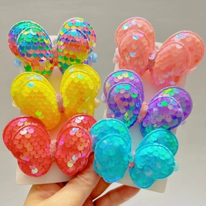 Detail view of colorful sequin bow hair ties set with shimmering scale texture for girls
