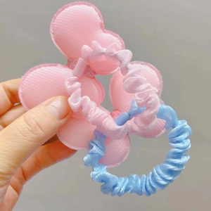Close-up of pink bow hair scrunchie and blue fabric elastic band set for girls