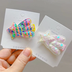Close-up of glitter star hair clips with colorful sequins on a white display card