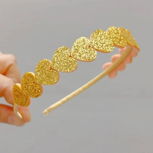 Detail of a sparkling gold glitter heart headband for girls with shining sequins
