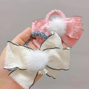 Dettaglio di fiocchi per capelli per bambine con pompon e elastici a fiori rosa