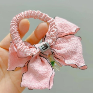 Dettaglio del fiocco rosa con bordi ondulati neri e ciondolo a forma di mughetto
