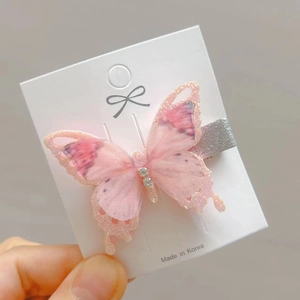 Detail of pink mesh butterfly hair clip with gold glitter edges and white rhinestones