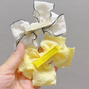 Detail of white and yellow pleated chiffon bow hair clips with alligator clips