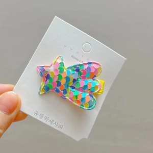 Colorful sequin star hair clip for girls featuring vibrant glitter details on a white card