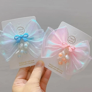 Detail view of handmade mermaid bow hair clips with pearlescent beads for girls