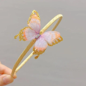 Detail of child hairband with a gradient mesh butterfly and sparkling gold glitter edges