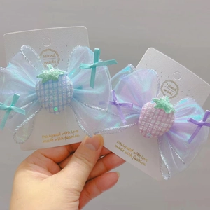Détail de nœuds papillon en organza avec breloques fraises à paillettes pour filles