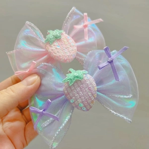 Détail de barrettes à nœuds roses et mauves avec fraise à paillettes et maille irisée