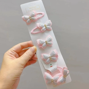 Detailansicht des 5-teiligen Sets mit rosa Glitzerschmetterling-Haarklammern und Haargummi