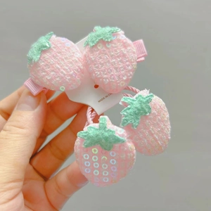 Gros plan détaillé d'un ensemble de trois accessoires fraise avec paillettes roses