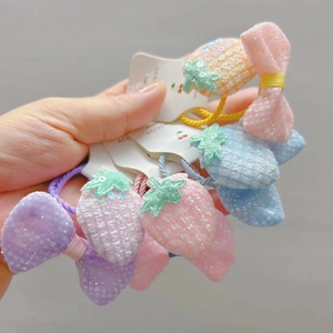 Détail d'élastiques à cheveux fraise à paillettes et nœuds en résille pastel