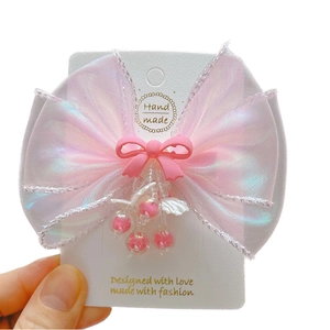Pink mermaid bow hair clip with beaded cherry charms on display card for girls
