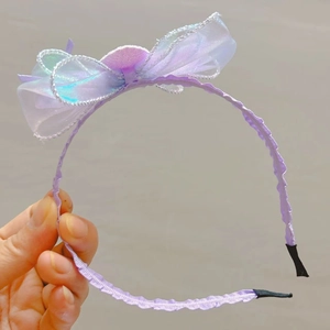 Détail du serre-tête avec nœud violet iridescent, bords argentés et pompon doux