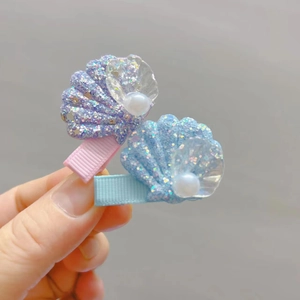 Détail de barrettes coquillage pour filles avec perles et tissu à paillettes