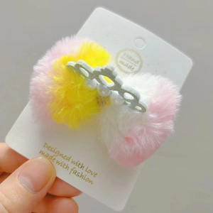 Dettaglio della clip per capelli in peluche con corona d'argento perlata e pelliccia sintetica