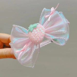 Détail d'un serre-tête nœud en organza avec finition aurora et motif fraise en paillettes