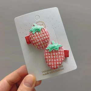 Détail de barrettes fraises rouges avec paillettes sur carte blanche pour filles