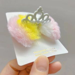 Dettaglio molletta corona d'argento con perline bianche e pelliccia rosa soft