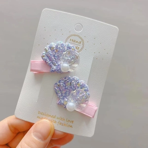 Détail de barrettes coquillage à paillettes avec perles et ruban fait main pour filles