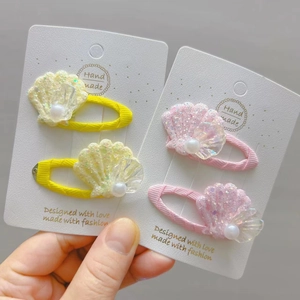 Détail de barrettes coquillages faits main avec paillettes et perles pour filles