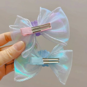Vue détaillée des nœuds en organza iridescent avec décor de coquillages et pinces en ruban