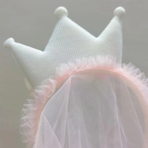 Detail of white fabric crown with pink mesh tulle veil for girls birthday parties