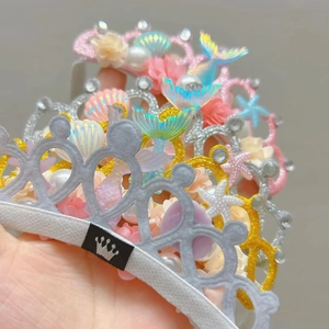 Makroaufnahme von Meerjungfrau-Kronenstirnband mit Perlen, Muscheln und Glitzersternen