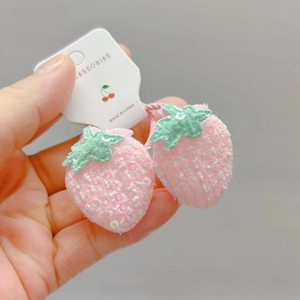 Détail d'une paire d'élastiques fraise rose avec des paillettes brillantes et étiquettes