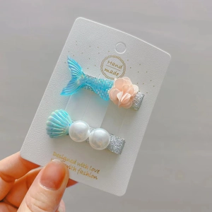 Two-piece girls' hair clips set featuring a glitter mermaid tail, seashell, and pearls